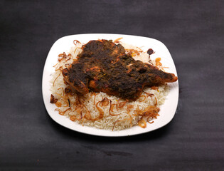 Pepper fried chicken Peshawar rice in a white ceramic plate in a dark background