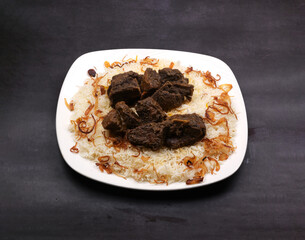 deep fried pepper beef Peshawar rice in a white ceramic plate in a dark background