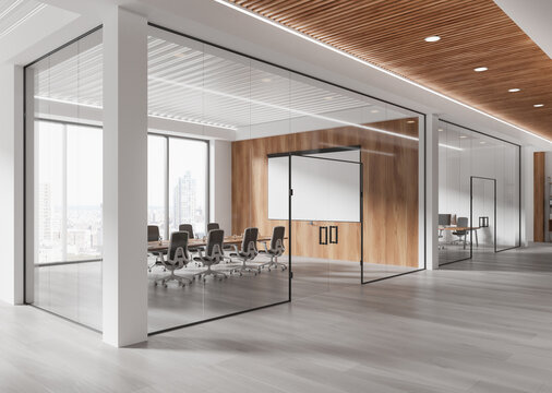 Modern open office interior with glass walls, wood panel accents, and city view in the background. 3D Rendering