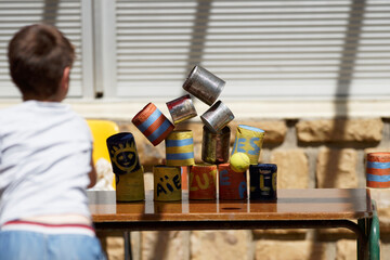 Kid playing the chamboule-tout game in a school feast  (kermesse de l'école)