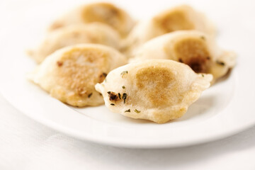 Dumplings with potato and cottage cheese stuffing (pierogi). Bright background.	