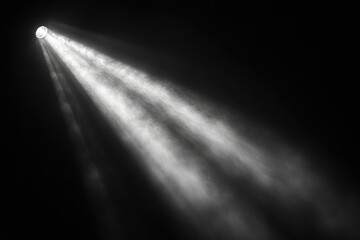A single spotlight illuminates a dark space, creating dramatic beams of light and atmospheric dust motes.