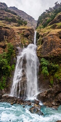 Wide panoramic view of the Chamche waterfall near Chamje village in Marsyangdi river valley in autunm cloudy day. Around Annapurna trekking, Lamjung region, Nepal.