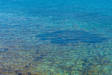 Obraz premium Crystal clear water gently washing over rocks in mallorca, spain