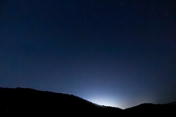Fototapeta premium A winter night sky full of twinkling stars spread out over the ridge.