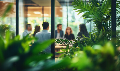 Motion blur image of an office buidling with business men and women holding a meeting. Plants in foreground.