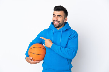 Caucasian man over isolated white background playing basketball and pointing to the lateral