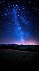 Night sky with Milky Way galaxy over a field.