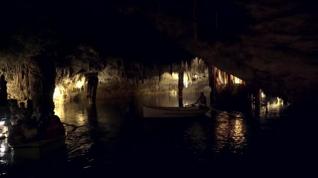 Tourists enjoying a serene boat trip through the stunning drach caves, marveling at the natural beauty of mallorca's underground