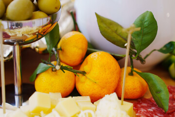 tangerine fruits with green leaves on the table with snacks. Fruit on the banquet table.