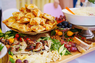 A large served table with salads, vegetables and barbecue. a variety of treats and snacks for the holiday. catering for a banquet. © Maria