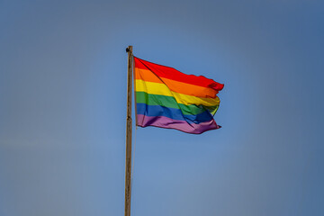 LGBTQ flag Low angle view of rainbow against a blue sky on a sunny day