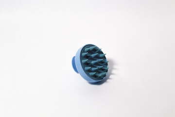 Blue scalp massager that can be used when washing hair on isolated white background
