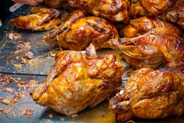 Whole chickens roasted on wooden charcoal barbecue grill