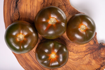 Fresh ripe sweet reddish brown and green kumato tomatoes close up