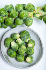 Green brussels sprouts on stalk on white table