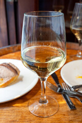 Glass of txakoli or chacolí slightly sparkling very dry white wine produced in Spanish Basque Country in typical pinchos bar in old part of San Sebastian or Donostia, Spain