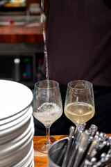 Pouring of txakoli or chacolí slightly sparkling very dry white wine produced in Spanish Basque Country in typical pinchos bar in old part of San Sebastian or Donostia, Spain