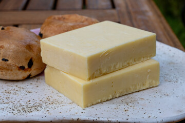 Block of aged cheddar cheese, the most popular type of cheese in United Kingdom and USA, natural cheese from cow milk