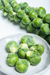 Obraz premium Green brussels sprouts on stalk on white table