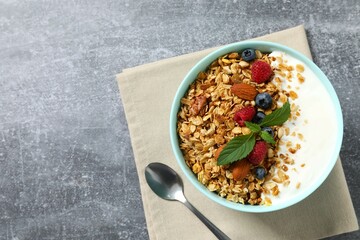 Delicious granola with berries and yogurt on a gray background