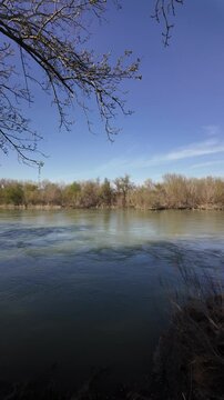 Panoramic view of ebro river flowing across natural landscape in Ginestar village, Spain, during a sunny day
