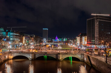 Dublin city centre at night during the Christmas holidays, featuring bustling activity and motion blur trails from passing traffic and pedestrians