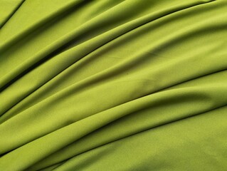 Abstrack green silk satin texture background. Beautiful wavy soft folds on the surface of the fabric.