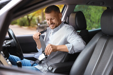 Man fastening seat belt in modern car