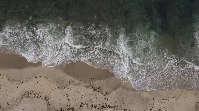 Olas cristalinas chocando en una playa de arenas blancas