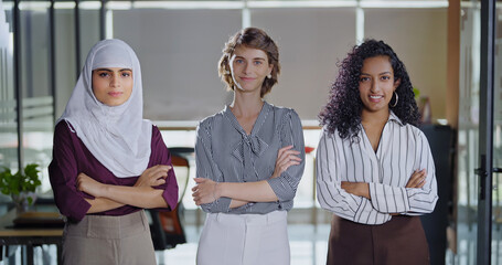 Indian Asian happy young adult gen z proud women lady wear hijab scarf fold hand look cam indoor work place teen mix girls curly hair expert female staff group team cross arms do pose job office day