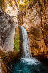 Majestic Waterfall Flowing through Rocky Mountains