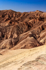 A mountain range with a blue sky in the background
