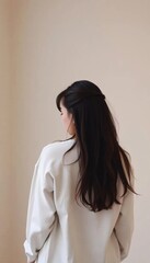 Fototapeta premium Young Asian woman sitting with her back turned, unable to see her face The background is a road.