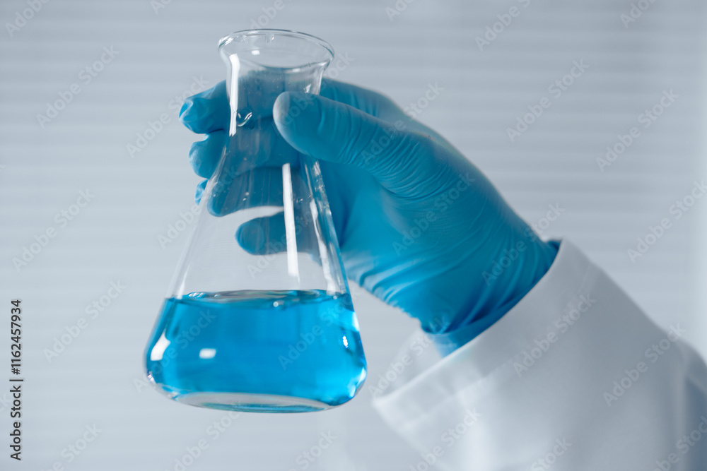 Aufkleber A dedicated scientist holds an Erlenmeyer flask with vibrant blue liquid, conducting experiments in a wellequipped lab, significantly contributing to advancements in science and technology