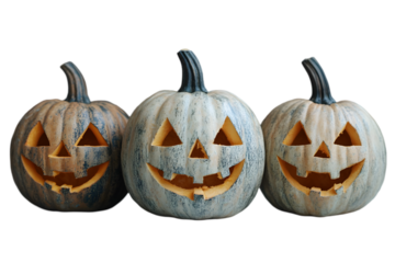 Three carved pumpkins with lit candles inside, isolated on a black background.