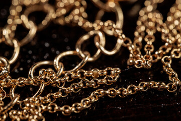 Close-up of intertwined gold chains, showcasing intricate details and textures.