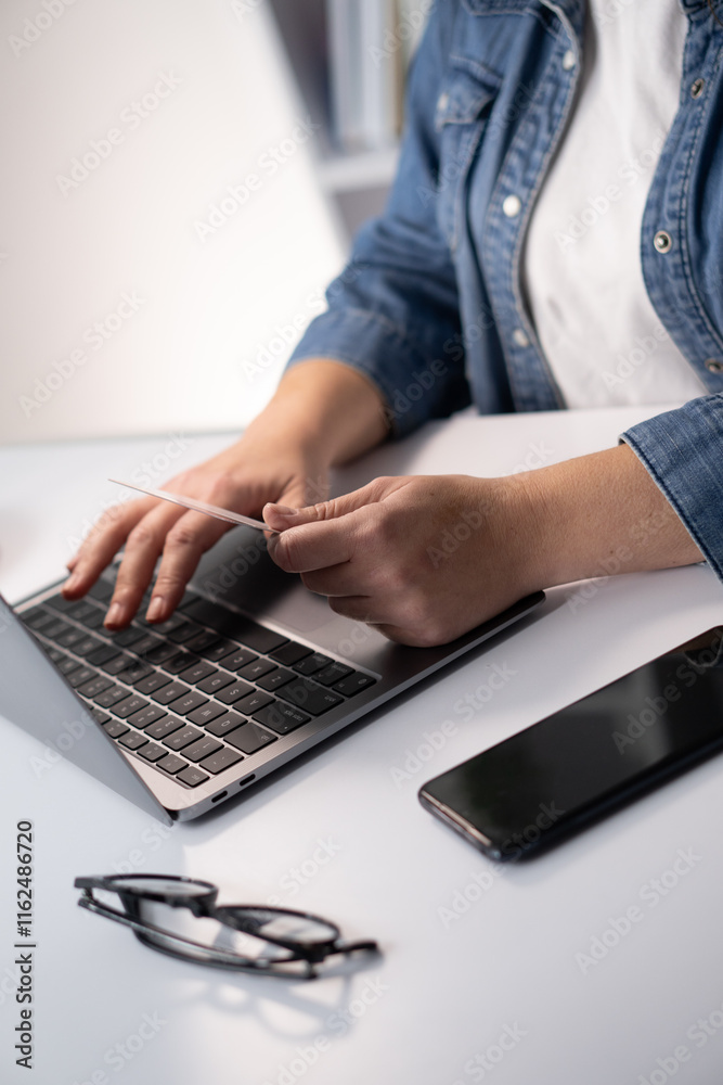 Poster A CloseUp Image Capturing a Person Actively Typing on a Laptop While Having a Smartphone Placed Nearby, Illustrating Modern Communication and Digital Productivity in a Workspace Setting