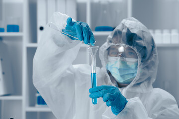 A scientist is carefully conducting an intricate experiment involving a test tube within a wellequipped laboratory setting to explore various facets of biochemistry and healthcare innovations