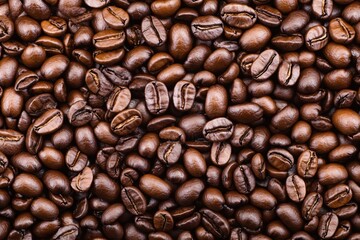 Obraz premium Close-Up View of Dark Roasted Coffee Beans on a Brown Background for Coffee Lovers