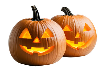 Fototapeta premium Two carved pumpkins with lit candle inside, isolated on a black background.
