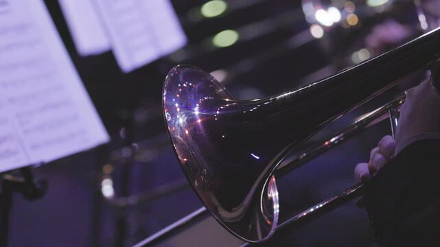 A musician playing a trombone during a live jazz performance in dim lighting