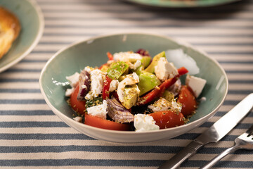 Greek Salad with Avocado. This vibrant dish features juicy tomatoes, creamy avocado, tangy feta cheese, and crisp red onions, all seasoned with Italian dried herbs