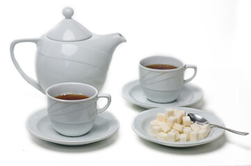 Warm tea served in elegant cups with sugar cubes on a delicate plate, perfect for a cozy afternoon break