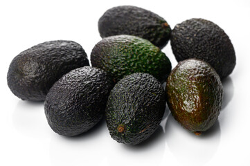 Fresh avocados arranged artistically on a reflective surface for a culinary display or food presentation
