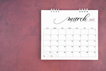 March 2025 desk calendar on red cement wall background. Page of annual monthly calendar.