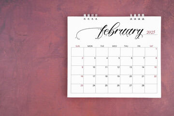 February 2025 desk calendar on red cement wall background. Page of annual monthly calendar.