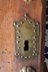 Magnifique serrure à clou sur une porte en bois, de style oriental et marocain couleur or en laiton