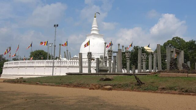 Ruins of a Buddhist temple on the background of the ancient Dagoba Thuparama. Anuradhapura, Sri Lanka