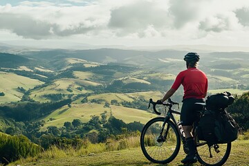 Cyclist admires scenic countryside vista from hilltop